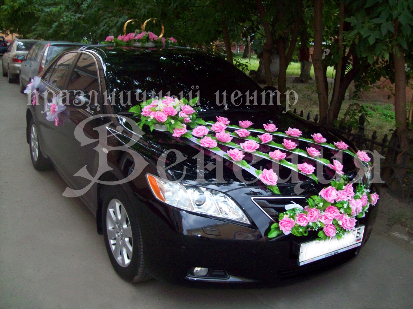 Черная Тойота Камри с цветами на капоте