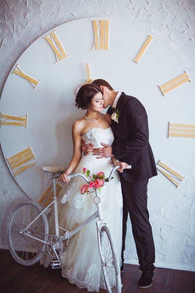 Жених и невеста возле белого велосипеда на фоне больших настенных часов - фото 2408747 Фотограф Афанасьева Екатерина