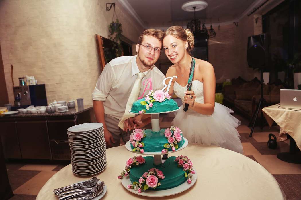 Жених с невестой, разрезающий трехъярусный свадебный торт, украшенный каскадом сахарных цветов  - фото 1211987 Фотограф Косова Александра