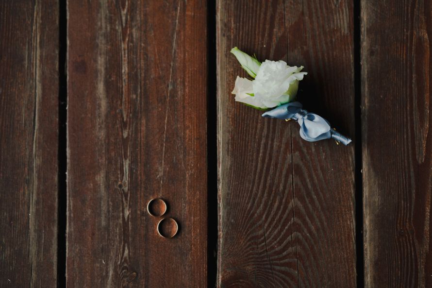 Бутоньерка из белых роз, декорированная синим атласным бантиком, возле свадебных колец - фото 954357 Фотограф Федорова Ольга