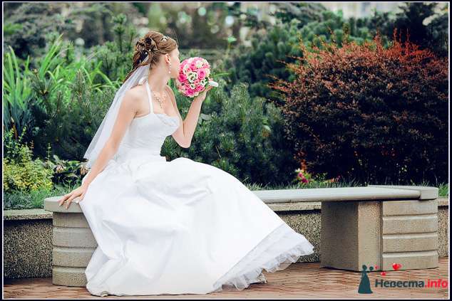 Невеста в белом длинном платье сидит на скамейке с букетом розовых цветов - фото 84695 Невеста01