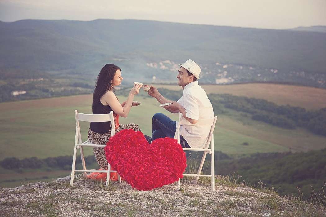 Парень и девушка сидят на белых стульях, украшенных большим красным сердцем - фото 2720603 Видеограф Сергей Крылов