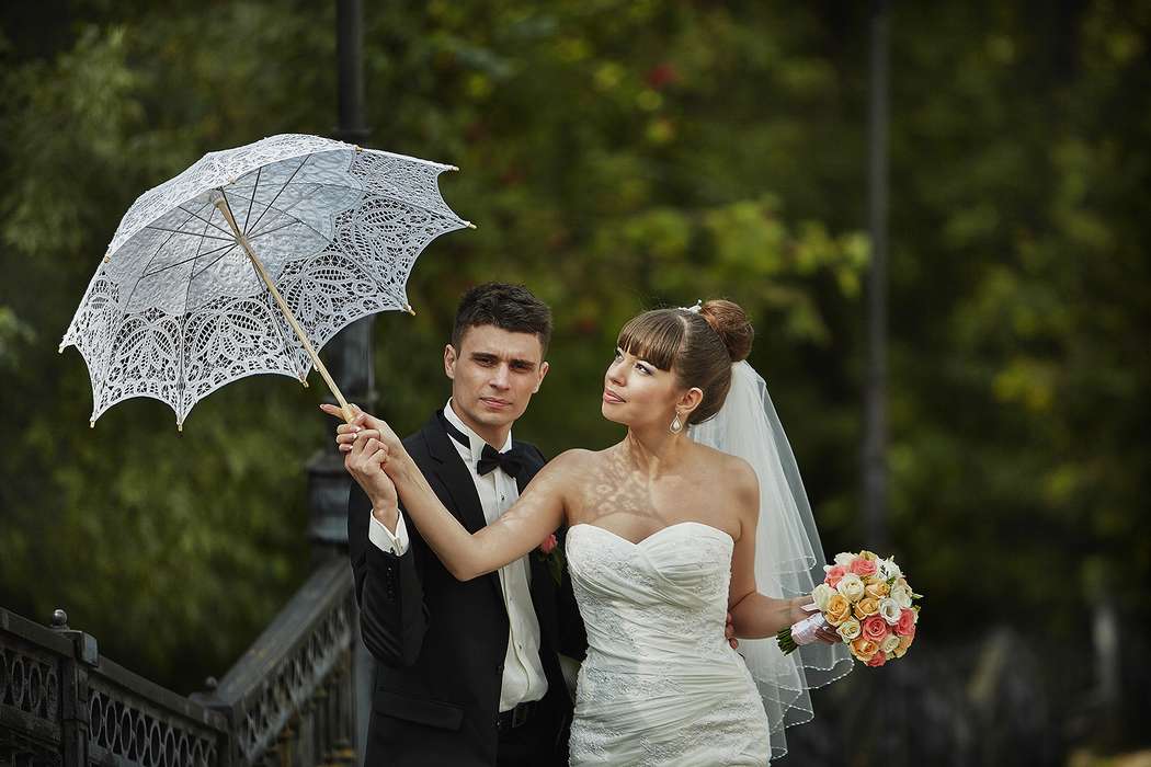 Невеста и жених держат в руках белый ажурный зонт ручной работы - фото 1400061 Константин Тростников Фотограф