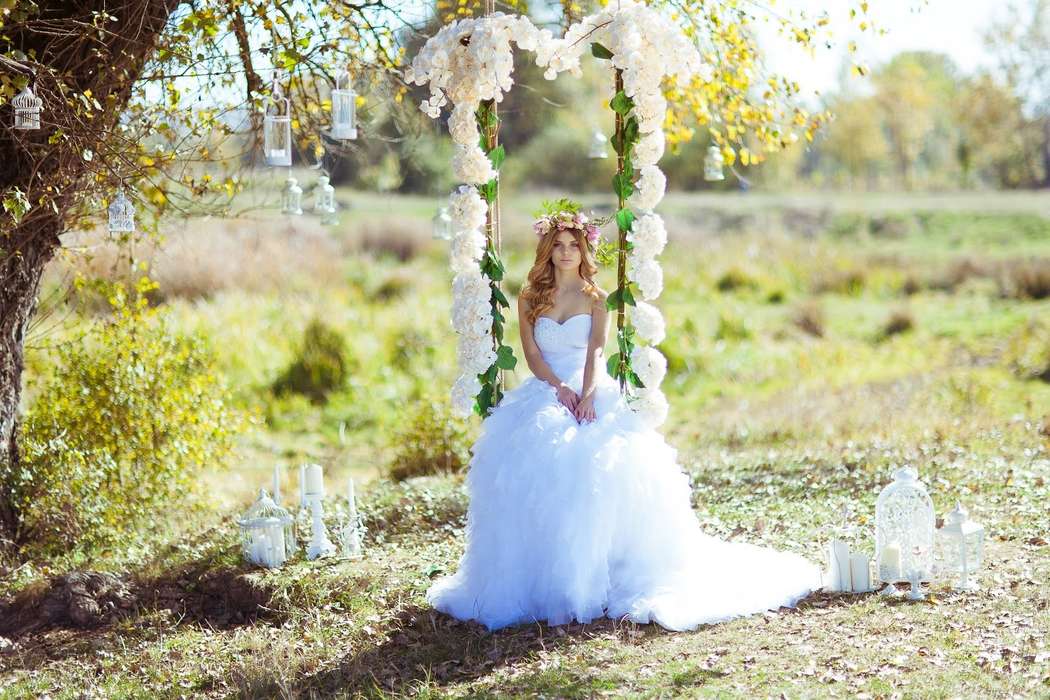 Невеста в белом длинном платье сидит на качелях, украшенных белыми цветами - фото 3641707 Мастерская Красивых Свадеб «Мери»
