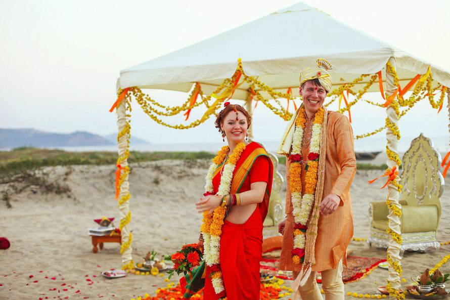 Жених в индийской одежде в оранжевых и белых тонах с гирляндами цветов на шее - фото 1284419 Фотограф Юлия Леденёва
