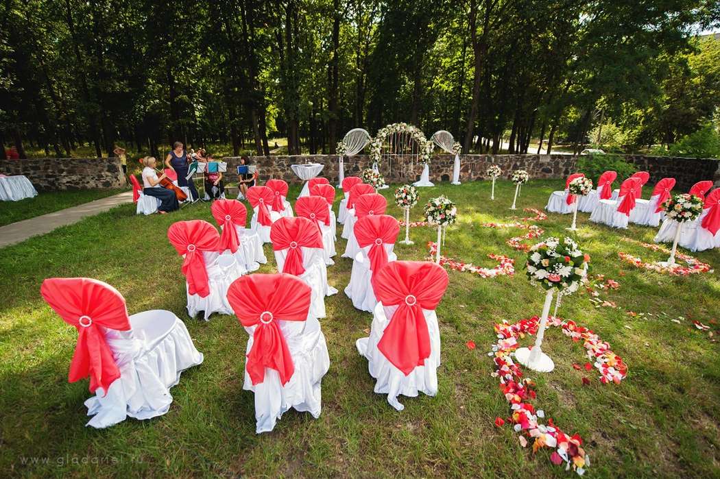 Свадебная подковообразная арка для выездной церемонии на природе, увитая цветами и с лентами. Стулья для гостей украшены белой - фото 1335651 Организация свадеб  в Mарокко