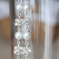 Комплект свадебной бижутерии - браслет из пяти ниток жемчуга Swarovski белого цвета с вставками со стразами и кристаллами и длинные, искрящиеся серьги.
