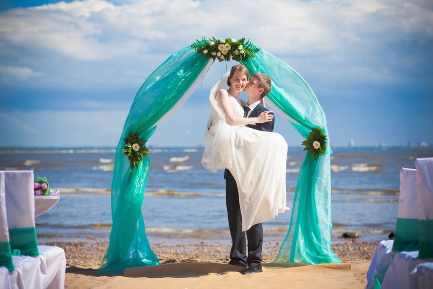 Подковообразная свадебная арка,  увитая цветами и тканью в зеленых тонах на фоне поборежья - фото 1559423 Фотограф Костромин Дмитрий 