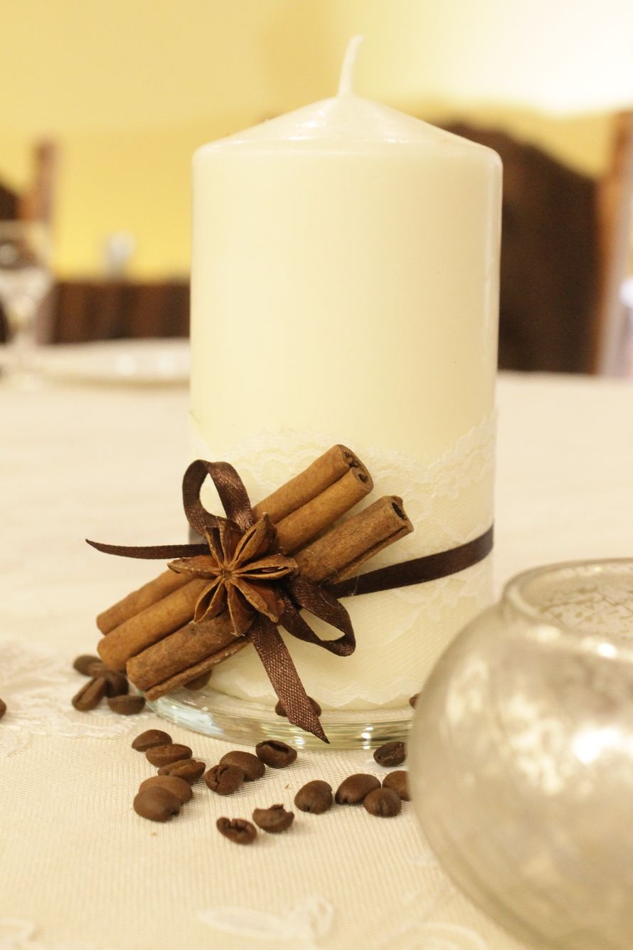 На праздничном столе стоит высокая толстая бежевая свеча, декорированная белым тонким кружевом и привязанными коричневой атласной - фото 3583719 Студия декора Айгуль Мироновой