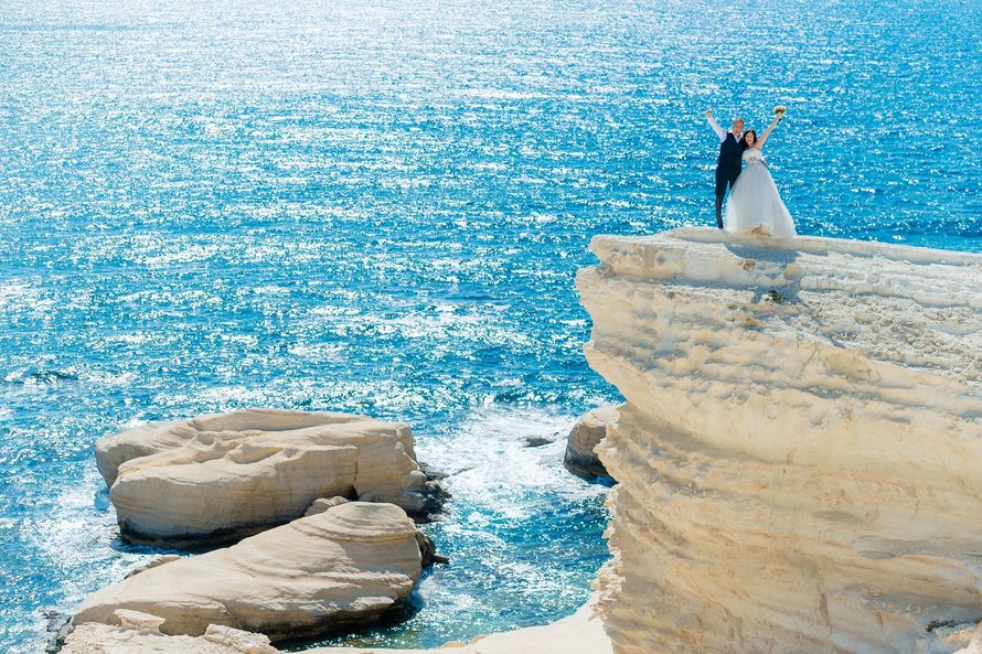 Жених и невеста, прислонившись друг к другу, стоят на фоне моря на скале - фото 3363719 AnutaHelfrich