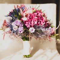 0ригинальный букет невесты из ярко-розовых гортензий, розовых орхидей, сиреневых эустом, голубых эрингиумов, декорированный белой лентой и декоративными элементами