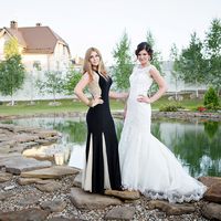 Невеста в длинном белом платье "русалка" с гипюром и подружка в длинном черном платье с бежевыми клиньями А-образного силуэта возле озера  