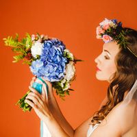 Образ невесты в английском стиле с венком на голове и букетом невесты из голубых гортензий, белых гвоздик, розовых роз и зелени в руках