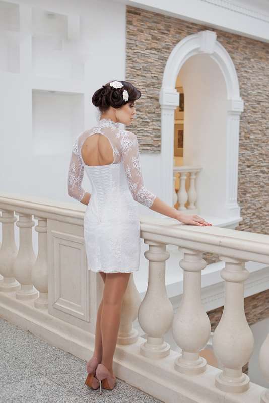 Невеста в коротком приталенном кружевном платье белого цвета с длинными рукавами и вырезом на спине  - фото 2166112 Свадебный салон Кармелия