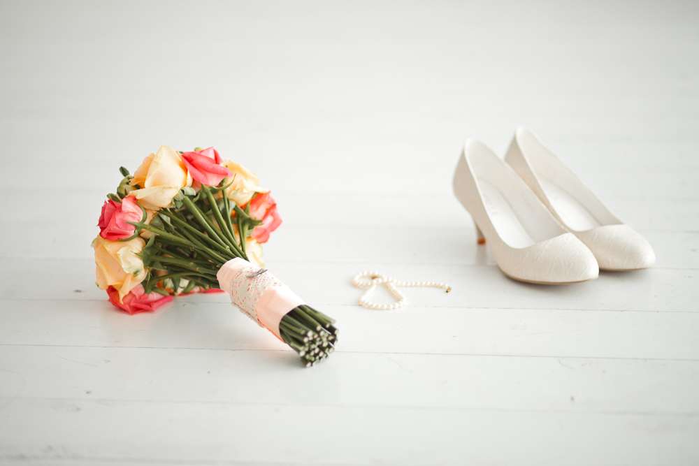 Белые туфли лодочка на маленькой шпильке лежат возле бус и букета цветов. - фото 2058858 Фотограф Мария Булычёва