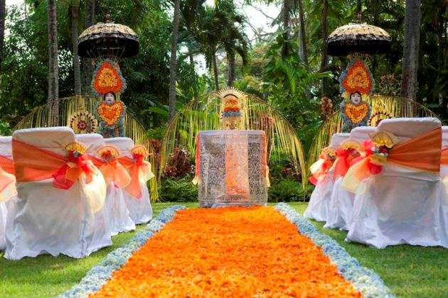 Стулья для гостей на выездной церемонии, украшенные  белыми чехлами с оранжевыми лентами с цветами - фото 2292578 Туристическое агентство Англетер