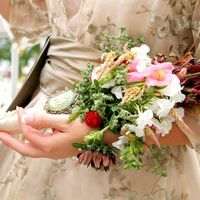 Невеста в свело-белом платье с букетом невесты из фиалок в руках