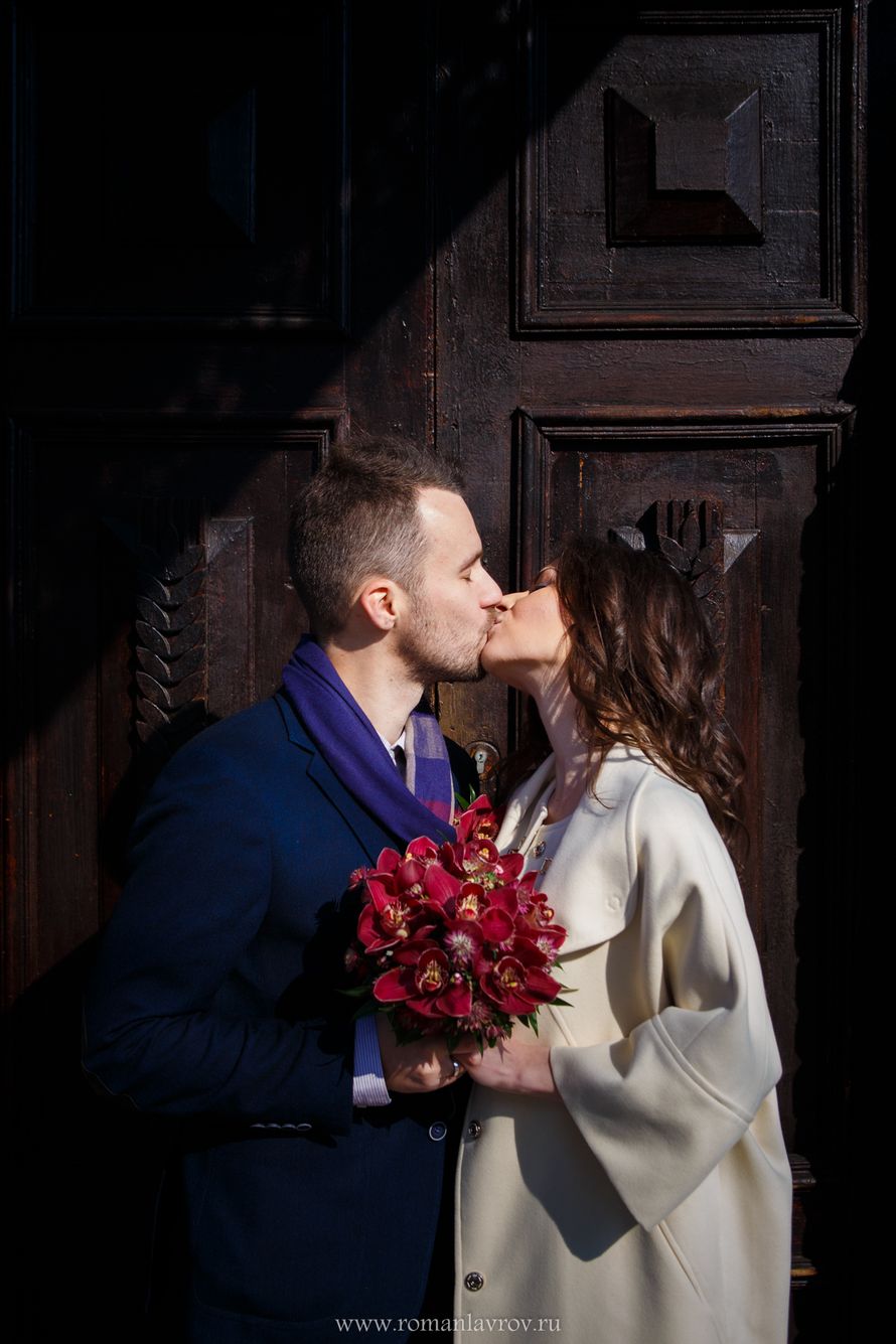 Жених и невеста, прислонившись друг к другу, стоят и целуются на фоне входных дверей - фото 3568207 Фотограф Роман Лавров