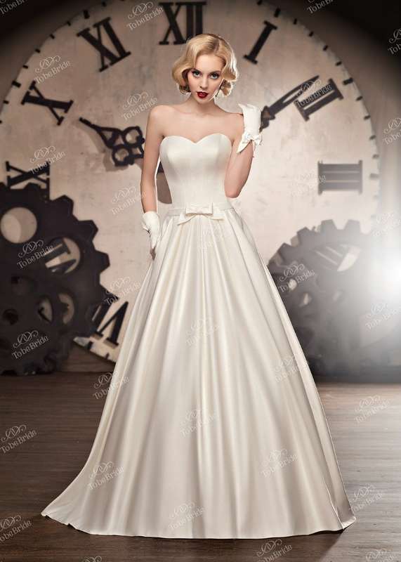 Атласное платье А-силуэта цвета айвори с гладким корсетом и бантом на талии - фото 2972385 Салон свадебной и вечерней моды "Белый Танец"  