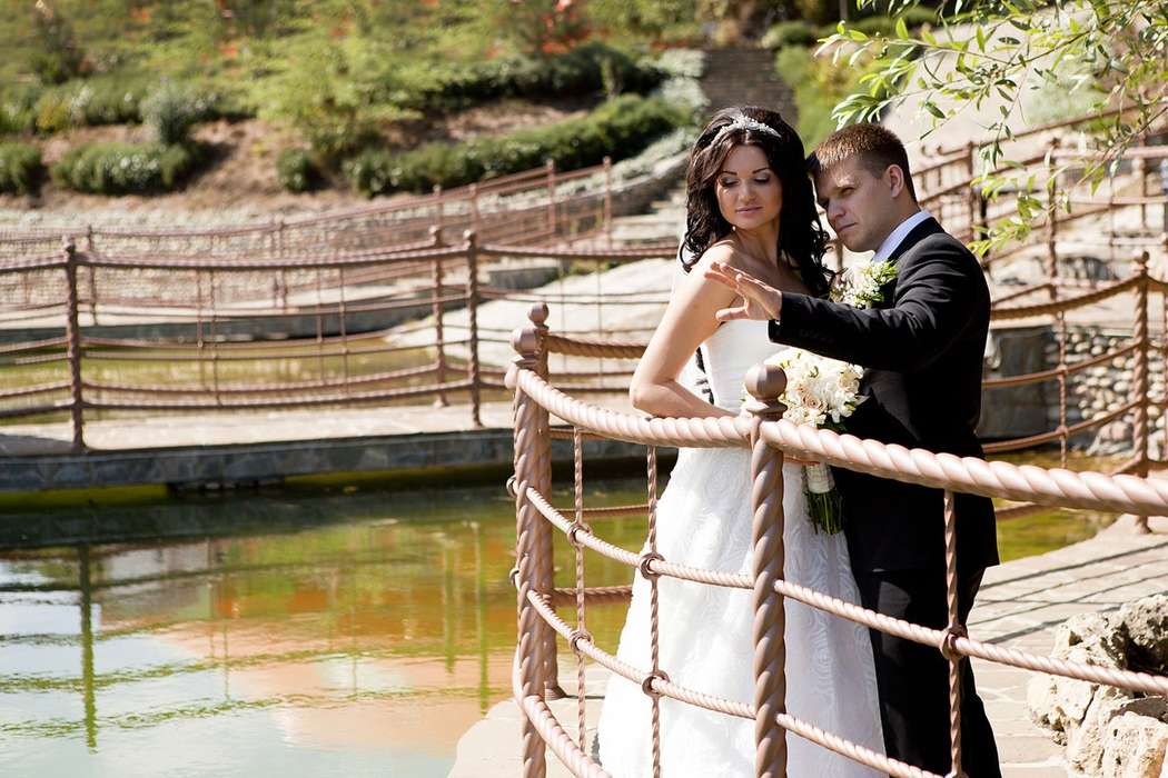 Жених и невеста, прислонившись друг к другу, стоят на фоне водоема и зелени - фото 2991043 Фотограф Кристина Дулепова