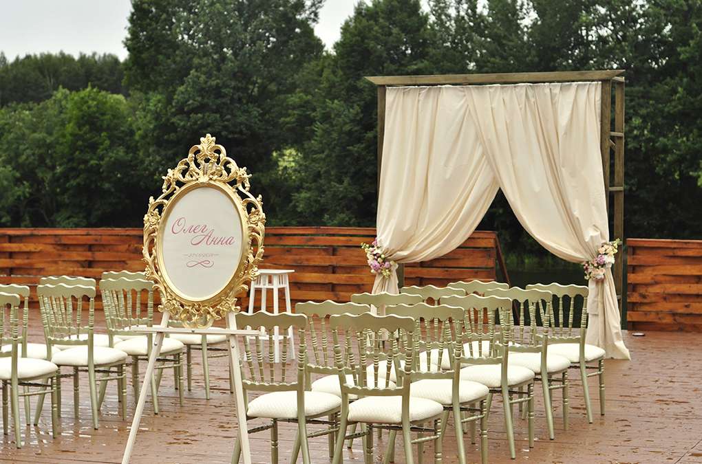 Свадебная квадратная арка для выездной церемонии на природе, украшенная персиковой тканью с цветами, на фоне стульев для гостей - фото 3152901 Weddinghappy - декор и оформление свадеб
