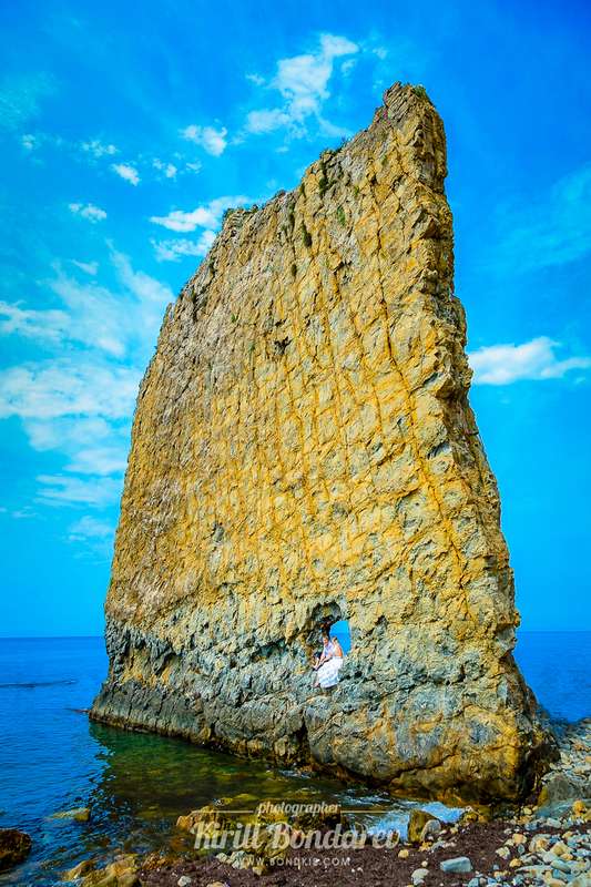 На пляже невеста сидит на камне  в белом платье, на фоне голубого неба - фото 3438353 Свадебный фотограф Кирилл Бондарев