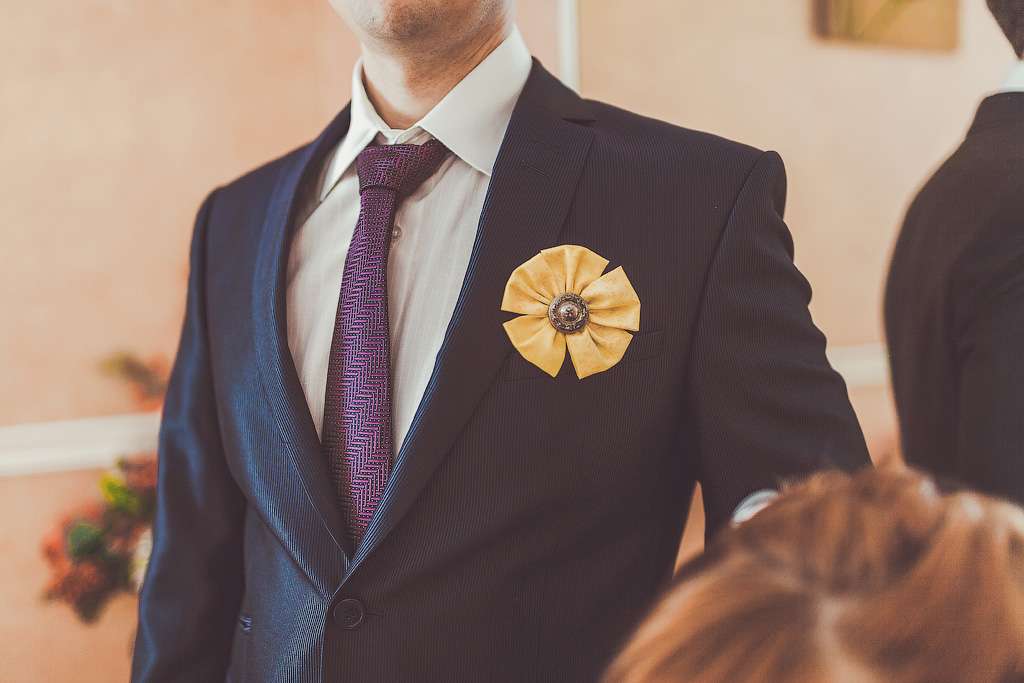 Бутоньерка ручной работы круглой формы, в виде цветка из желтой атласной ткани с коричневой брошью в середине, в петлице пиджака - фото 770689 Фотограф Гамова Ирина