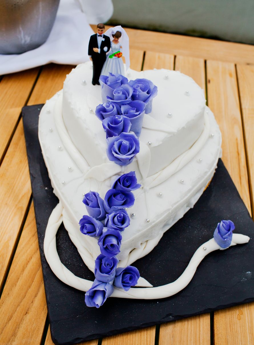 Двухъярусный свадебный торт, белого цвета, выполнен в форме сердца, украшенными сахарными розами и фигурками жениха и невесты - фото 1866311 Фотограф Яна Яворская