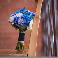 Букет невесты из голубых гортензий и скабиоз, белых роз, серой брунии и зеленого эвкалипта на деревянном стуле