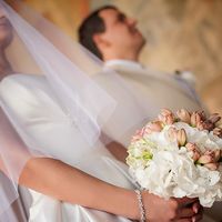 Невеста в белом пышном атласном платье и белой вуальной фате с букетом в руках из розовых альстромерий и белых гортензий