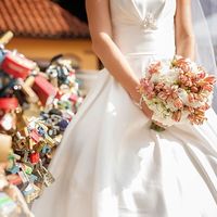 Невеста в белом пышном атласном платье с букетом в руках из розовых альстромерий и белых гортензий