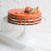 Милый торт с цитрусовой глазурью. украшенный экзотическими фруктами и сладостями