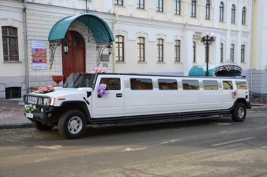 Черно- белый "Hummer" на фоне старинного здания, украшенный экибанами и бантами, стойкой из колец в цветах. - фото 801253 Компания "Малахит ДВ" - аренда авто