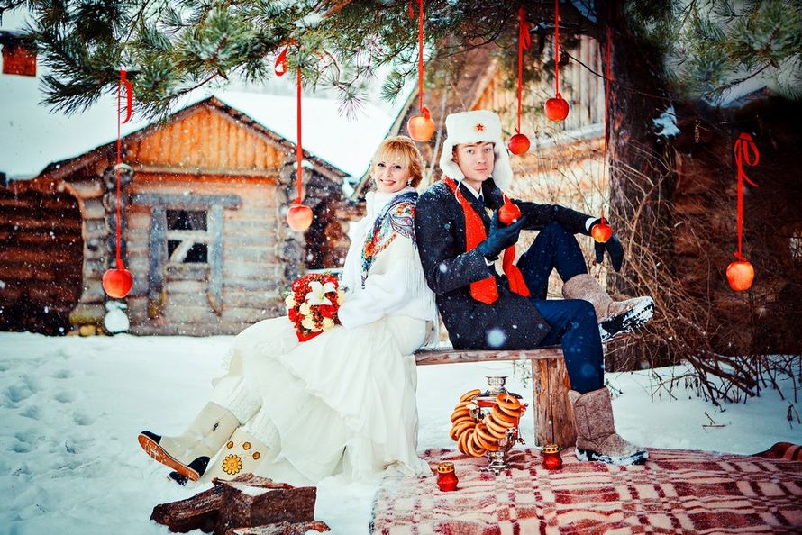 На фоне зимних избушек, под елью, украшенной красными шарами, на ящике сидят жени и невеста - фото 2293860 Фотограф Владимир Никонов