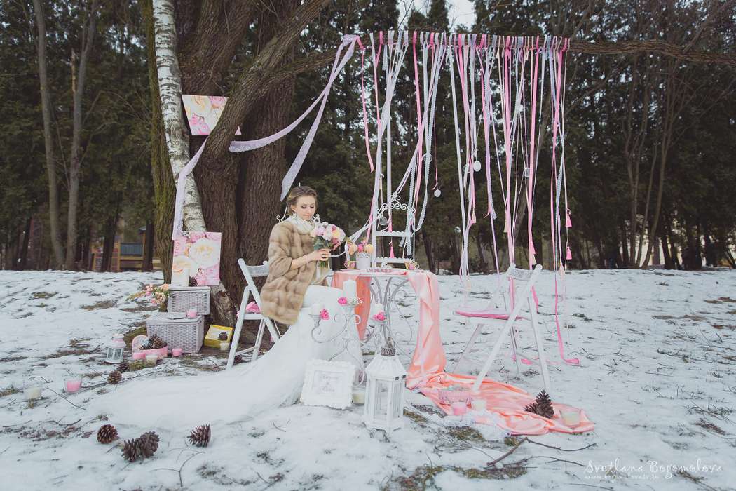 Невеста, держа в руках розовый букет цветов, сидит под деревом, украшенным розовыми лентами, за розовым столиком - фото 2651863 Светлана Богомолова - фотограф
