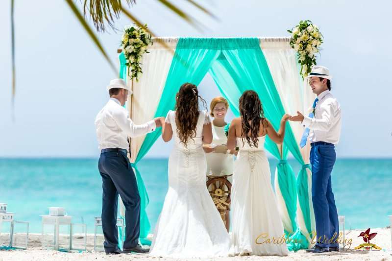 На фоне бирюзовой беседки стоят молодожены, взявшись за руки, идет регистрация брака - фото 2723893 Caribbean Wedding - свадьба в Доминикане