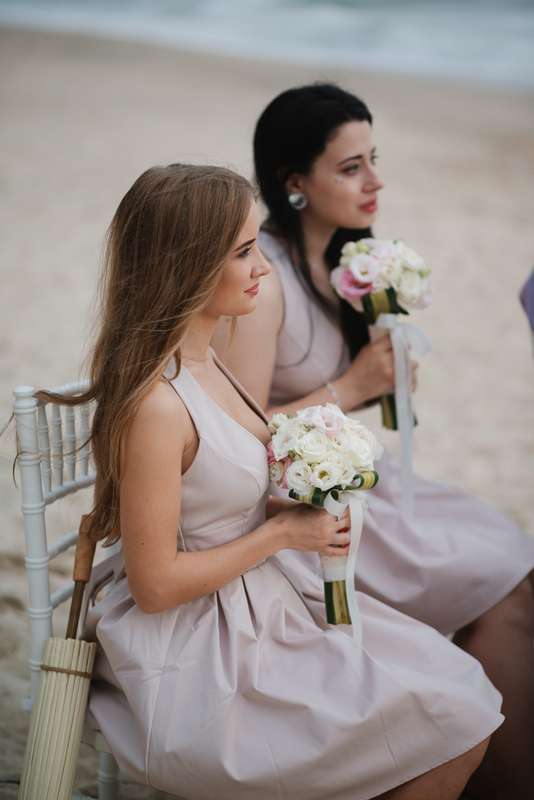 Подружки невесты в бежевых коротких с расклешенным низом платьях без рукава, с глубоким вырезом горловины сидят на скамейке с - фото 1195797 Julia_Chernova