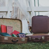 Чемоданчики с книжками и чемодан для бонбоньерок рядом со стилизованной стремянкой