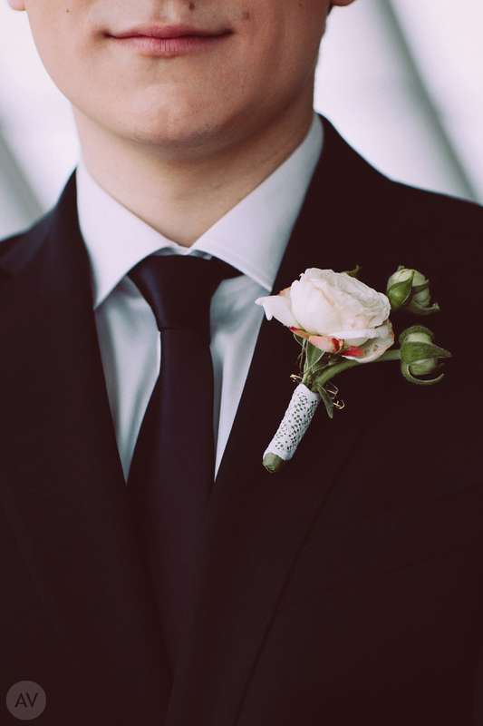 Бутоньерка из белой эустомы, декорированная белой кружевной лентой, в петлице черного пиджака - фото 2122858 Фотограф Антон Воронков
